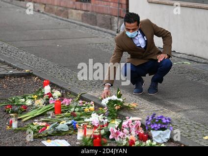 Halle, Germany. 09th Oct, 2020. Ismet Tekin, operator of the Kiez Döner neighbourhood, lays flowers at a memorial plaque for the victims of the attack in Halle/Saale in front of his snack bar. One year after the right-wing terrorist attack on the highest Jewish holiday Yom Kippur in Halle, the victims are commemorated with events and prayers. Credit: dpa picture alliance/Alamy Live News Stock Photo