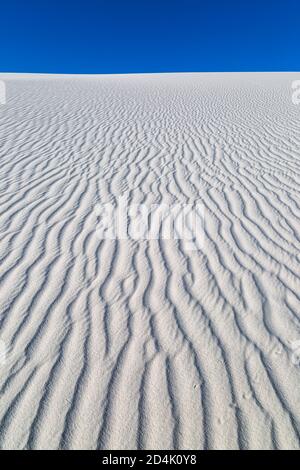 Ripples in white sand dunes against a clear sky, at White Sands National Park, New Mexico Stock Photo