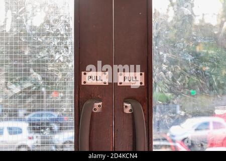 Pull engraved on plastic plate on wooden glass door of a metro station in Ireland Stock Photo