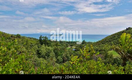 Panoramic view over the north of Praslin island, Seychelles with tropical rainforest and the two small islands Cousin and Cousine as well as Mahe. Stock Photo