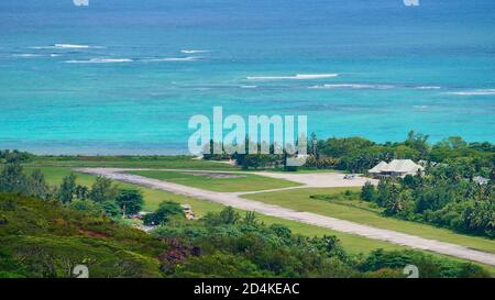 Aerial view of airfield located near the coast in the north of Praslin island, Seychelles with a small plane parking in front of the terminal building. Stock Photo