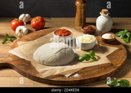 Preparing Homemade Uncooked Cheese PIzza with Sauce and Dough Stock Photo