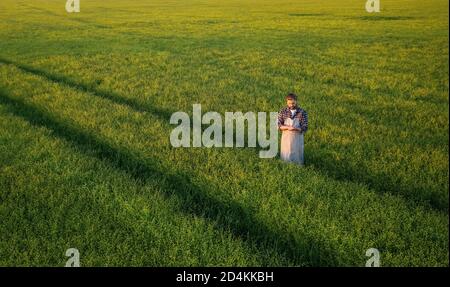 Technician standing in green field Stock Photo