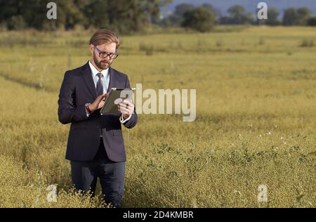 Man holding tablet standing field Stock Photo