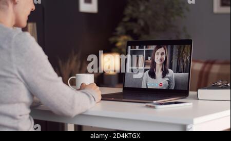 Woman using laptop calling friend Stock Photo