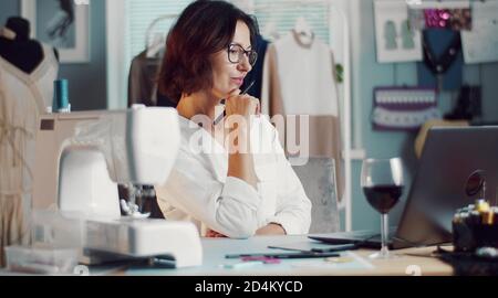Seamstress working laptop in workshop Stock Photo