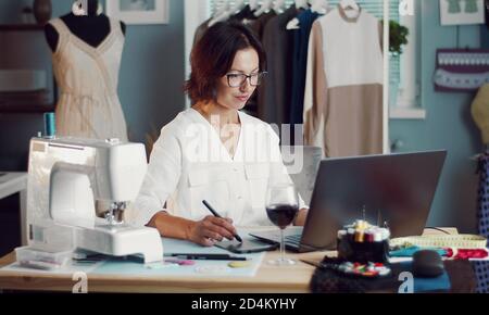Dressmaker creating design using laptop Stock Photo