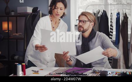 Two fashion designers comparing sketches Stock Photo