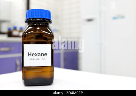 Selective focus of hexane liquid chemical compound in dark glass bottle ...