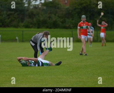 Derry, Northern Ireland.  Injured player receives treatment during hurling game between Na Magha and Lavey.  ©George Sweeney / Alamy Stock Photo Stock Photo