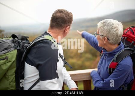 An elderly couple enjoying the view from the top of a watchtower on a beautiful autumn day Stock Photo