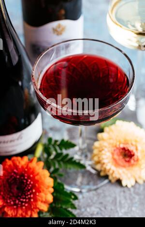 red and white wine on vintage blue background with natural flowers Stock Photo