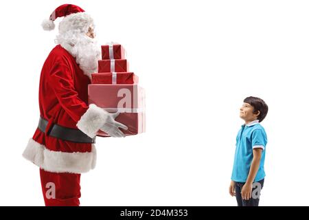 Santa Claus giving a pile of Christmas presents to a boy isolated on white background Stock Photo