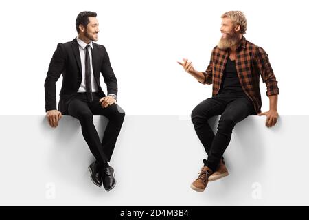 Young casual bearded man and a businessman sitting on a panel and having a conversation isolated on white background Stock Photo