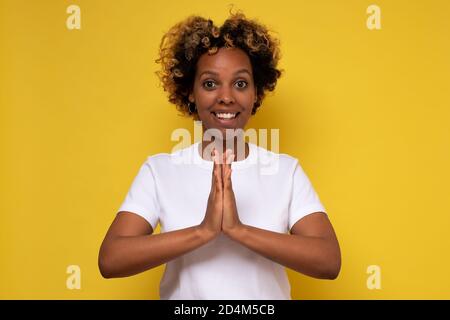 African american happy woman greeting with Namaste geture Stock Photo
