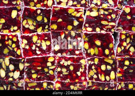 Background of Turkish delight. a pile of Turkish delicacies with pomegranate and pistachios. Stock Photo