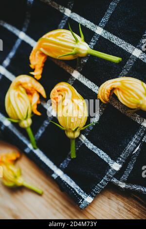Yellow courgette flowers on a black towel Stock Photo