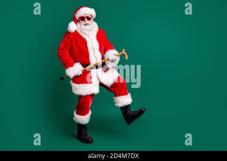 Full length body size view of his he nice attractive bearded cheerful cheery glad comic childish funky Santa dancing with cane having fun celebration Stock Photo