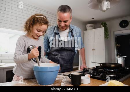 Caucasian daughter and father baking together in the kitchen at home on fathers day Stock Photo