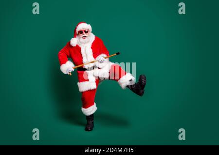 Full length body size view of his he nice attractive bearded cheerful cheery comic funky funny Santa father dancing with cane having fun celebratory Stock Photo