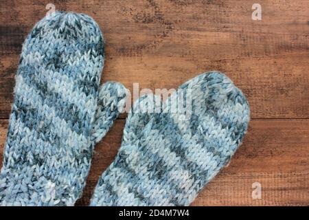 Pair of knitted mittens on a wooden background. Cozy winter concept. Top view, copy space Stock Photo