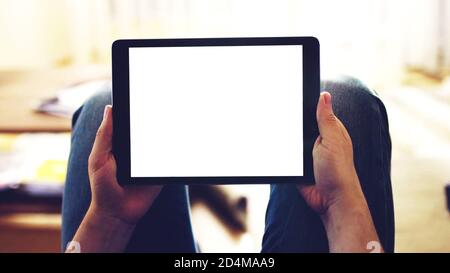 hands holding black Tablet mobile phone device with white empty mockup blank screen, copy space background. Stock Photo