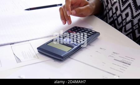 Women hand using a Scientific Calculator close up, exam preparation papers on the table. School or university study, maths and physics concept backgro Stock Photo