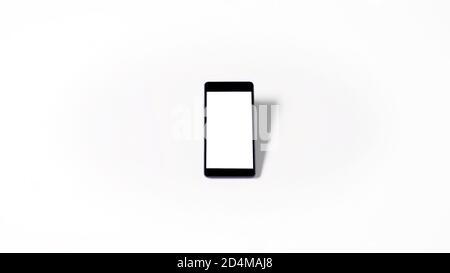 Mobile phone with empty white blank screen mockup isolated on white background. With shadow and copy space. Stock Photo