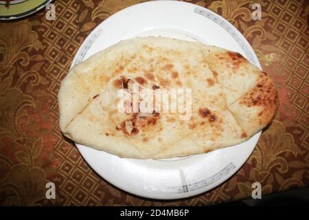 A flatbread is a bread made with flour, water, and salt, and then thoroughly rolled into flattened dough. Many flatbreads are unleavened, although som Stock Photo