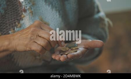 Homeless old woman counting last coins. Close up. High quality photo Stock Photo