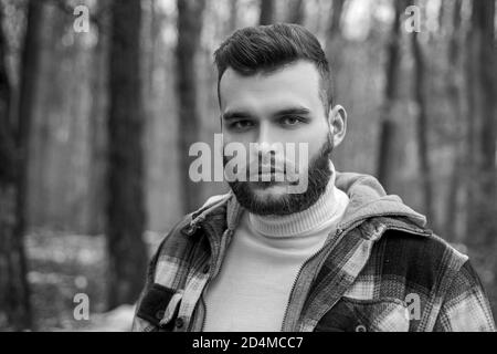 Well groomed hipster. Lumbersexual concept. Bearded lumberjack checkered clothes. Brutal man walk in forest. Hipster lifestyle. Masculinity and Stock Photo