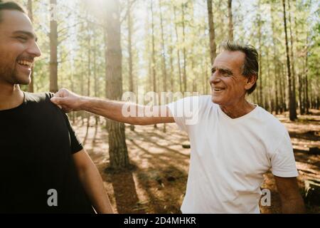 Young caucasian happy spending time with adult son in the woods on a run Stock Photo