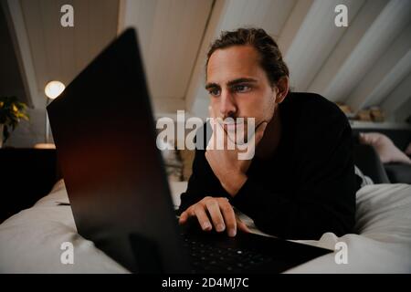 Young caucasian male student working from home and his laptop Stock Photo