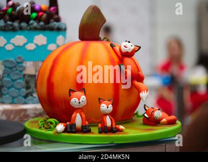 pumpkin pie made of sugar dough. the figure of the Fox is decorated with candies. Stock Photo
