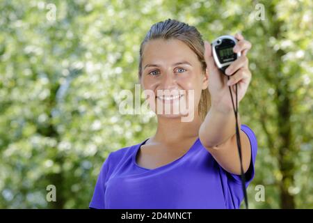 portrait of female athlete showing stopwatch Stock Photo