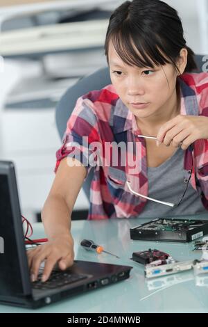 female asian computer technician using laptop Stock Photo