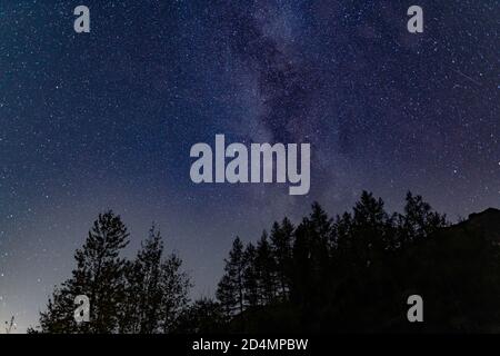 The milky way over the trees by Blea Tarn in the English Lake District Stock Photo