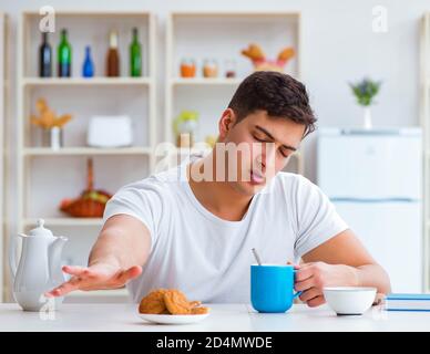 The man falling asleep during his breakfast after overtime work Stock Photo