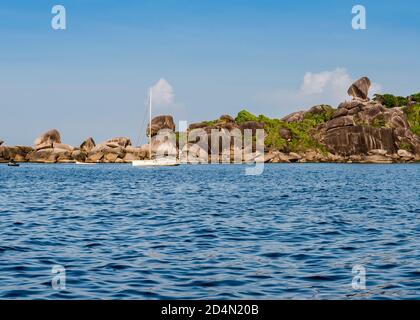 Picturesque rocks, forest and yacht near one of the Similan Islands in Thailand Stock Photo