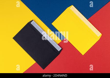 Black and yellow envelopes on multicolored paper background. Geometry background minimal concept. Multicolored paper with envelopes. Creative flat lay Stock Photo