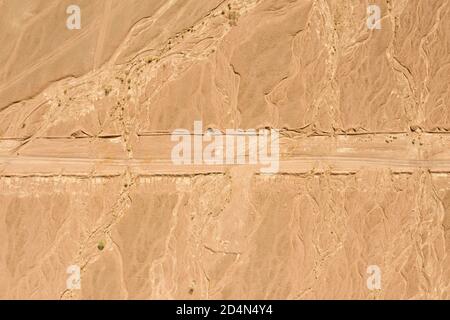 Desert landscape with single dirt path crossing, Aerial image. Stock Photo