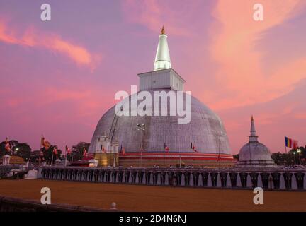 Ancient Dagoba Ruwanweli Maha Seya against the backdrop of a colorful sunset. Anuradhapura, Sri Lanka Stock Photo