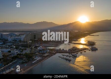 Sunrise over Eilat and The Red Sea, with waterfront hotels and Edom mountain ridge in the horizon, Aerial view. Stock Photo