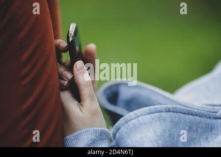 Details with the hands of a woman using a mobile phone. Stock Photo