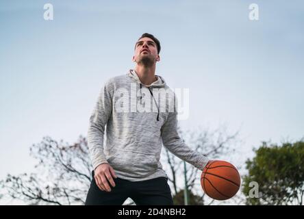 Portrait of young basketball player playing outdoors. Sport concept. Basketball concept. Stock Photo