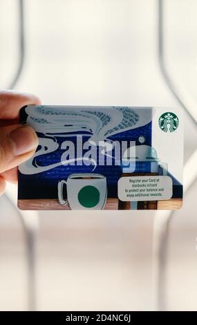 A person holding a Starbucks card. Stock Photo