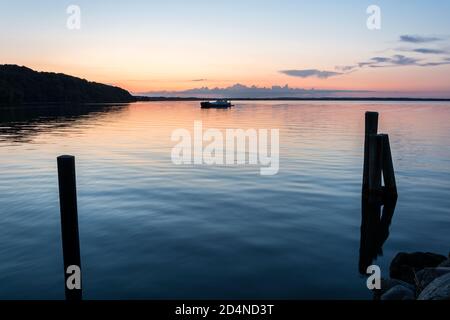 Scenic colourful sunset over the calm Baltic Sea with houseboat in Langballigau, Germany Stock Photo