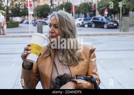 Shallow focus shot of a woman sitting in a cafeteria drinking coffee Stock Photo