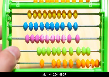 Colorful plastic abacus toy with multi colored beads, closeup. Kids and math, primary school simple mathematics teaching aids, children, education Stock Photo