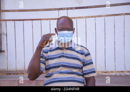 Middle-aged African male pointing to his face mask - concept of social responsibility Stock Photo